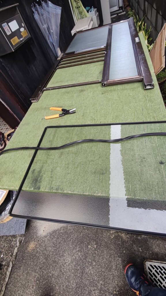 現場で玄関引き戸のガラスをカットしている様子