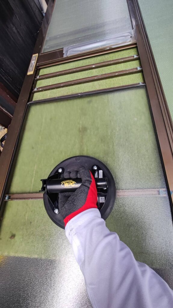 玄関引き戸に新しい型板ガラスを組み込む作業